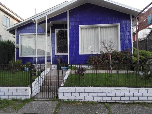 a purple house with a fence in front of it at Hospedaje Los Calafates in Ancud