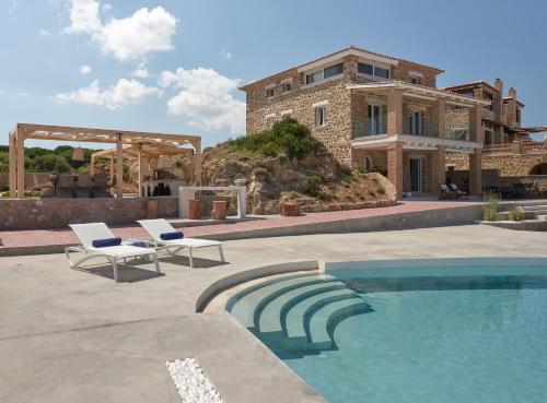 a house with a swimming pool in front of a house at Arismari Luxury Villas in Vasilikos