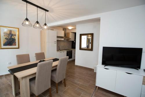 cocina y comedor con mesa y TV en Sweet Apartment City Center Split en Split