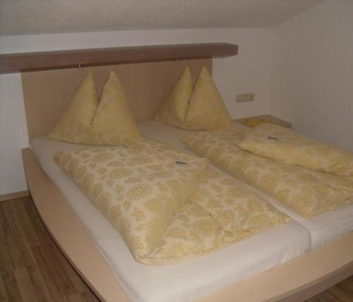 a bed with two pillows on top of it at Haus Benedikt in Heiligenblut