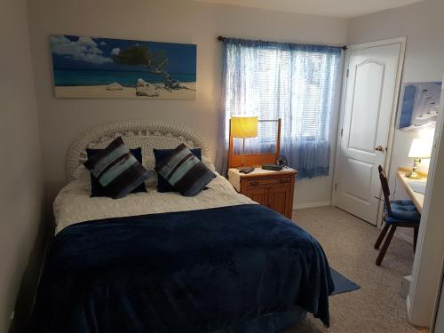 a bedroom with a bed, desk and a painting on the wall at Davis Bay Bed & Breakfast in Sechelt