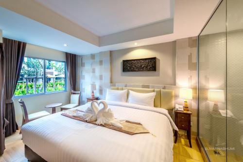 a hotel room with a bed and a window at Suvarnabhumi Ville Airport Hotel in Lat Krabang