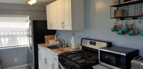 a kitchen with a stove top oven next to a sink at 1st floor cottage! One Block to Beach, Convention Center and Wildwood Crest! in Wildwood