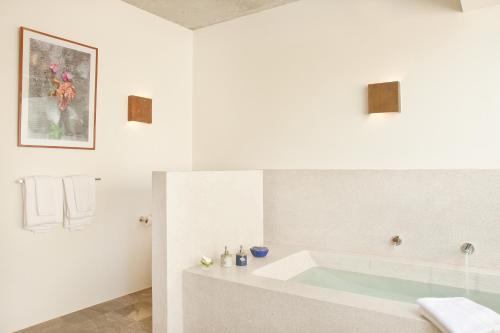 a white bathroom with a tub and a shower at Templation Hotel in Siem Reap