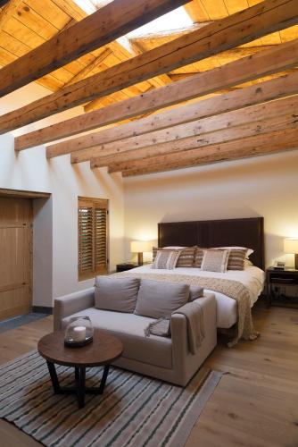 a bedroom with a bed and a couch and a table at La Casa Rodavento in Valle de Bravo