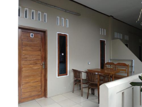 a dining room with a wooden door and a table at Hotel Putra Sindang Asih in Batukaras