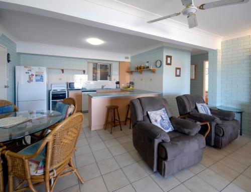 a living room with two couches and a kitchen at Marcel Towers Holiday Apartments in Nambucca Heads