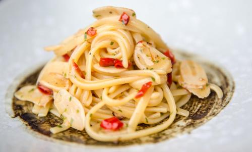 a plate of pasta with chicken and tomatoes at Baba Beach Club Natai Luxury Pool Villa Hotel by Sri panwa - SHA Plus in Natai Beach