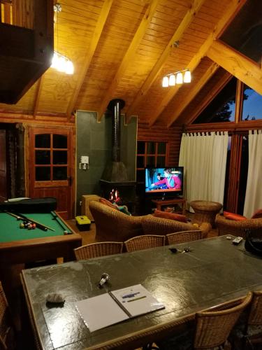 a living room with a pool table and a tv at lodge con piscina privada, parcela de campo. in Algarrobo
