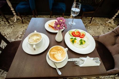 uma mesa com pratos de comida e uma chávena de café em Boutique Hotel Aristocrat em Irkutsk