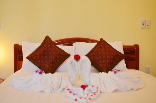a bed with white towels and pillows on it at Panda Garden Homestay in Hoi An