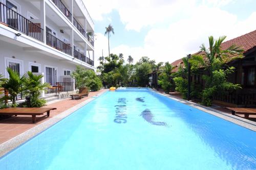 a swimming pool with a dolphin in the middle of a building at MAY Bungalow in Mui Ne