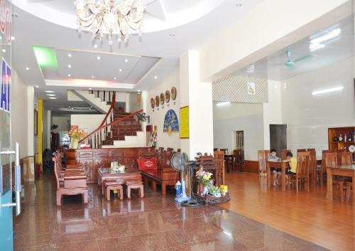a restaurant with wooden tables and chairs and a chandelier at Lam Dat Hotel in Ninh Binh