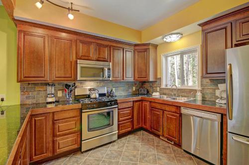 a kitchen with wooden cabinets and stainless steel appliances at Spruce Creek Lodge Home in Breckenridge