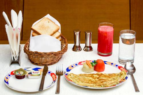 a table with a plate of food and a basket of bread at Ramoji Greens Inn in Pedda Ambarpet