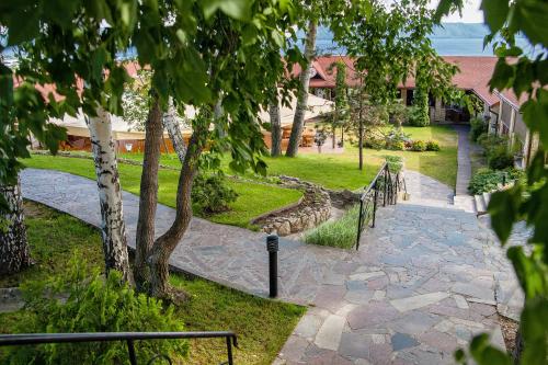 una passerella in pietra in un parco con un albero di Park Hotel a Tolyatti
