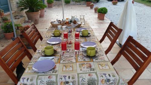 a table with plates and glasses on a patio at B&B Cervare in Montelupone
