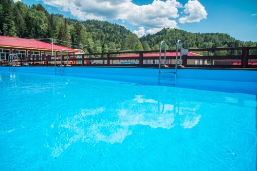 a large swimming pool with blue water in front of a building at Tourist complex Gornoe Ozero in Artybash
