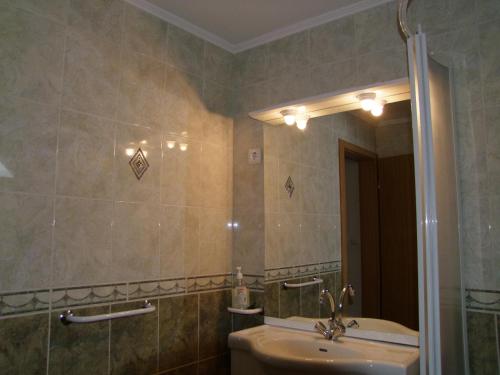a bathroom with a sink and a mirror at Rajna Apartmanház in Bogács