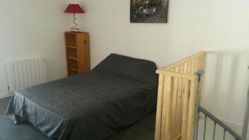 une chambre avec un lit et une table de chevet dans l'établissement 7 rue des sables, à Les Sables-dʼOlonne