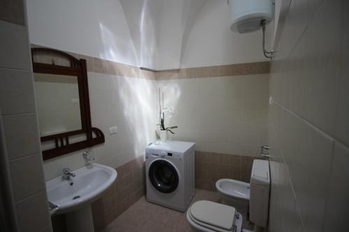a bathroom with a toilet sink and a washing machine at Home Holiday Salento Casa Agrosì Don Camillo in Presicce