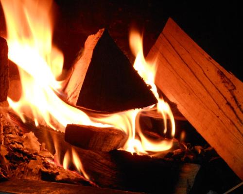 a fire in a stone oven with flames at Ferienwohnung Gimplinger in Ellmau