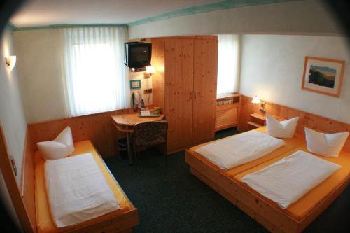 ein Hotelzimmer mit 2 Betten und einem Schreibtisch in der Unterkunft Hotel Rebstock in Rust