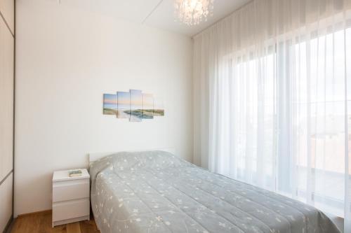 1 dormitorio con cama y ventana grande en Cosy city apartment en Pärnu