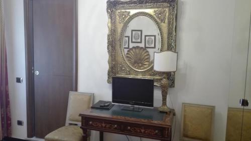 a desk with a painting on the wall next to a lamp at Hotel Villa Luisa in Rapallo