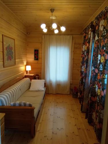 a living room with a couch and a window at Villa Tiirinkallio in Nilsiä