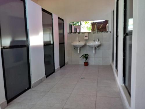 a hallway of a bathroom with two sinks and mirrors at Backpacker Kitara House in Tarapoto