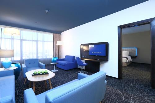 a hotel room with a couch and a tv at Park Inn by Radisson Najran in Najran