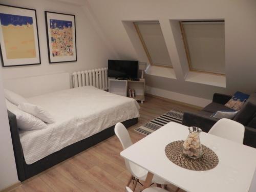 sypialnia z łóżkiem, stołem i kanapą w obiekcie Apartamenty Starówka w Kołobrzegu