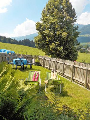 a yard with two lawn chairs and a fence at Appartement Anneke in Niedernsill