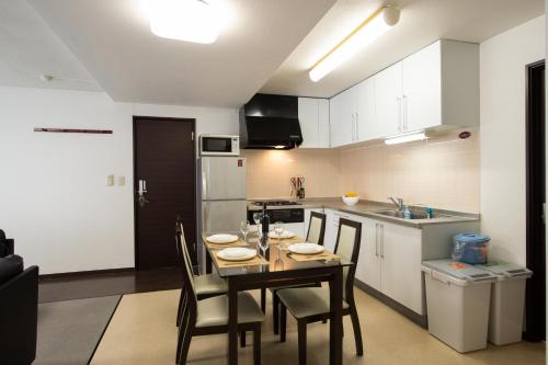 a kitchen and dining room with a table and chairs at Asuka in Kutchan