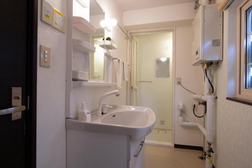 a white bathroom with a sink and a toilet at Asuka in Kutchan