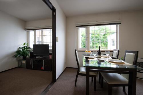 a dining room with a table and chairs and a mirror at Asuka in Kutchan