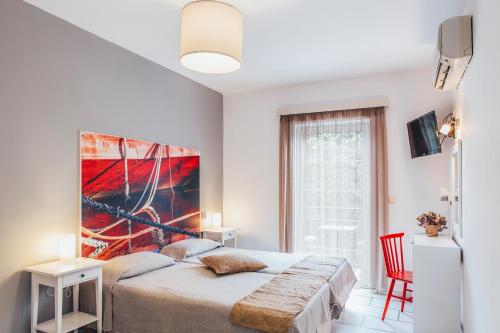 a bedroom with a bed and a painting on the wall at Hotel Semeli in Agios Prokopios