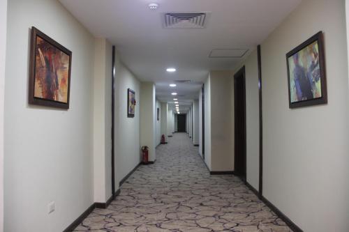 a hallway with a long corridor with paintings on the walls at Rehana Plaza Hotel in Cairo