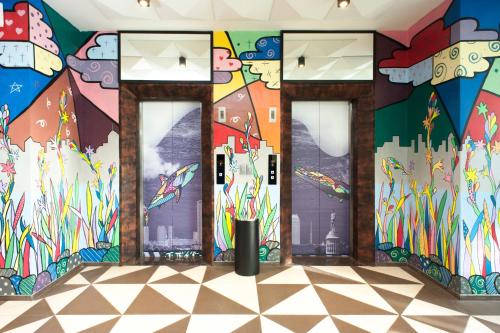a room with doors with a painting on the wall at MaxOneHotels at Dharmahusada Surabaya in Surabaya