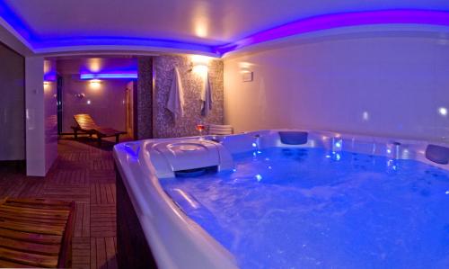 un bagno con grande vasca e illuminazione viola di Rooms and Apartments Villa Dama a Pola (Pula)