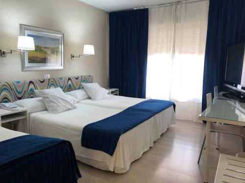 a hotel room with two beds and a television at Hotel Virrey in Arnedo