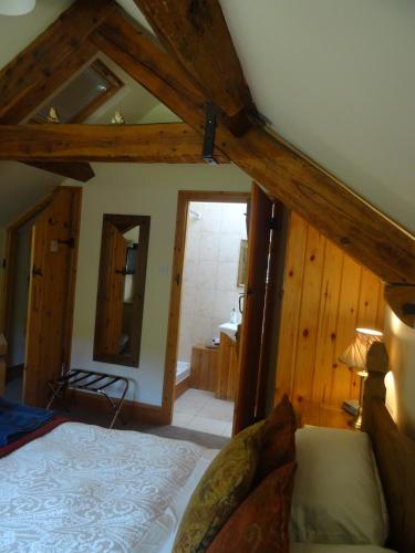 a bedroom with a bed and a mirror in a room at Middle Woodbatch B&B in Bishops Castle