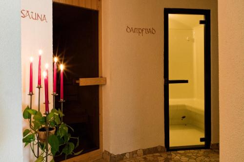 un bagno con specchio e due candele rosse di Hotel Stocknerhof a Naz-Sciaves