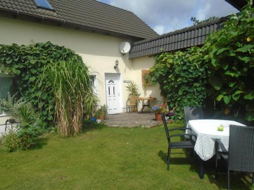 a garden with a table and chairs in a yard at Ferienhaus nahe vom Weissen See in Wesenberg