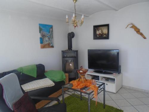 a living room with a couch and a tv at Ferienhaus nahe vom Weissen See in Wesenberg