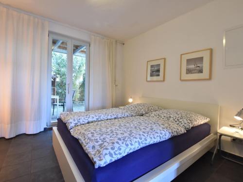 een slaapkamer met een bed en een groot raam bij Modern Apartment with Garden in Wismar in Wismar