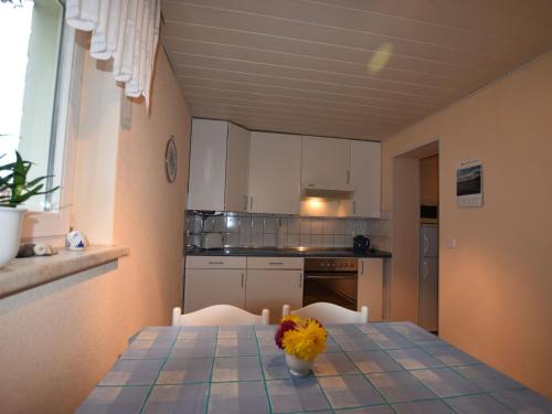 a kitchen with a table with a vase of flowers on it at Sch ne Wohnung in Kr pelin in der N he von Meer in Kröpelin