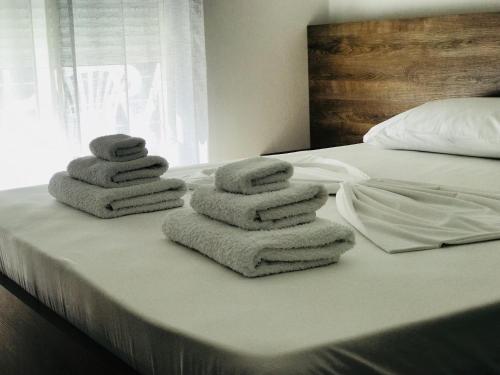 una pila de toallas sentadas encima de una cama en Viktoria's Apartments, en Shëngjin