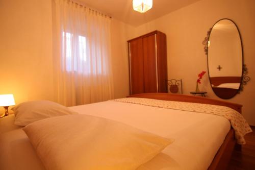 - une chambre avec 2 lits et un grand miroir dans l'établissement App with a lovely patio, à Mali Lošinj